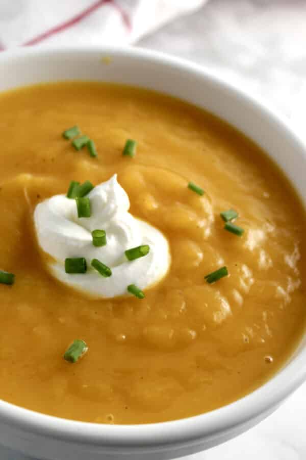 butternut squash soup with a garnish of sour cream and chives