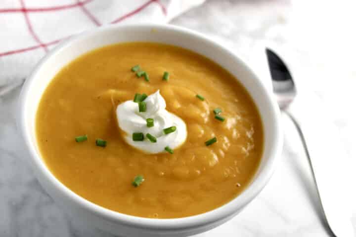butternut squash soup with a garnish of sour cream and chives