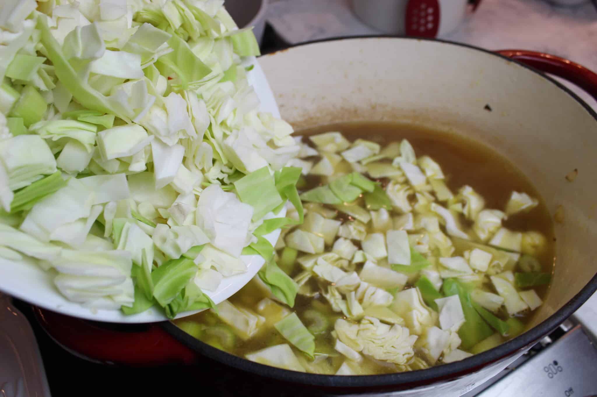adding cabbage to cabbage soup