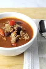 close up view of mexican soup showing ground beef, red peppers and kidney beans