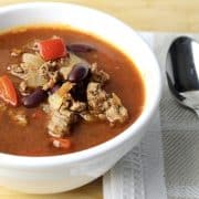 close up view of mexican soup showing ground beef, red peppers and kidney beans