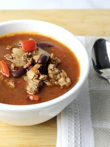 close up view of mexican soup showing ground beef, red peppers and kidney beans