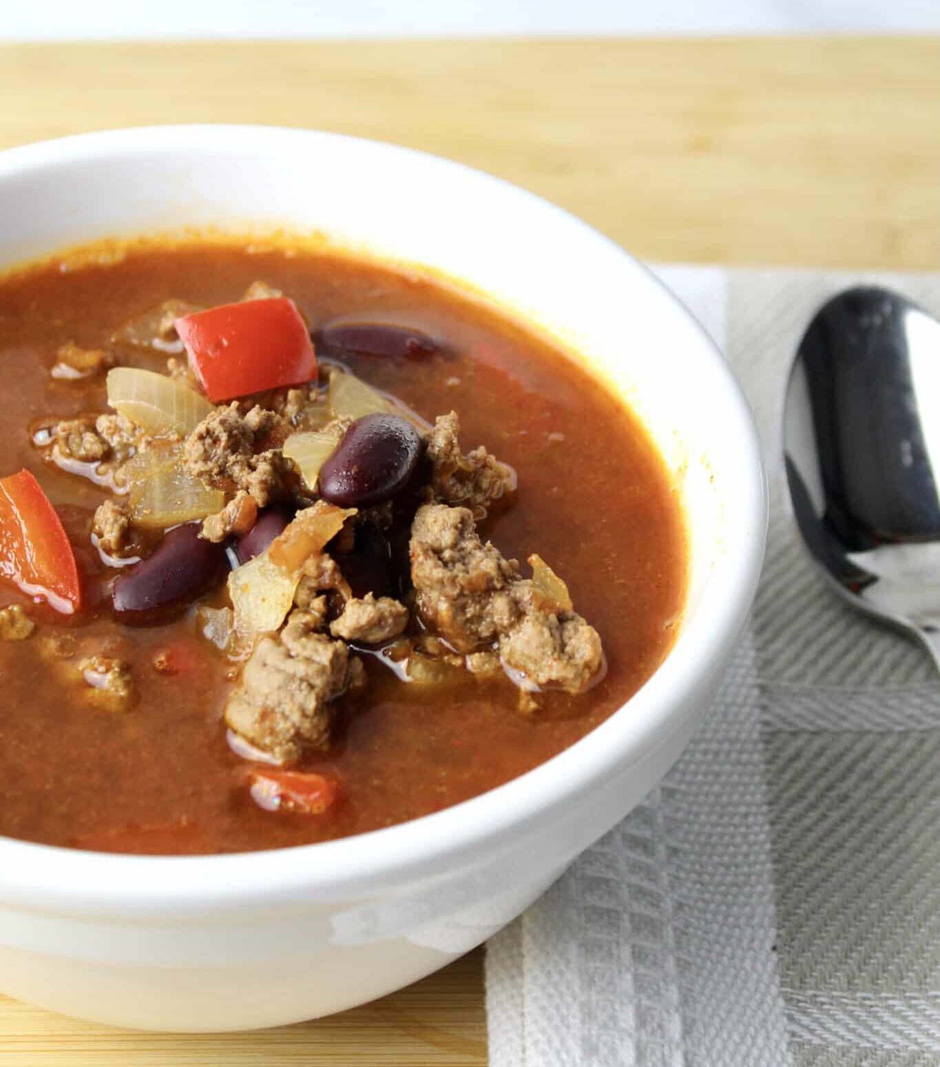 close up view of mexican soup showing ground beef, red peppers and kidney beans