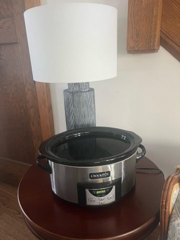 crockpot with water on end table in front of blue lamp