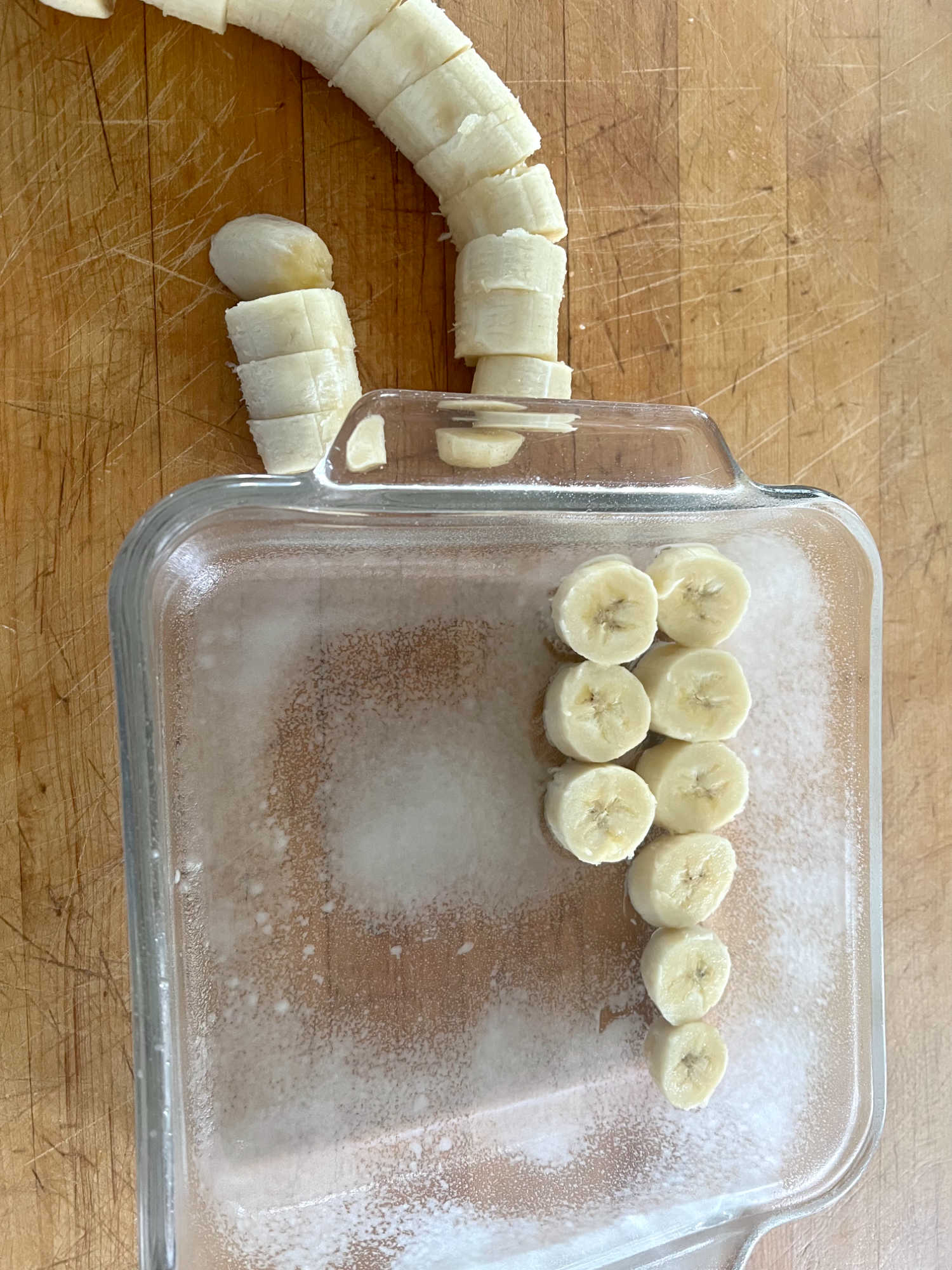 sliced bananas in the bottom of a baking dish