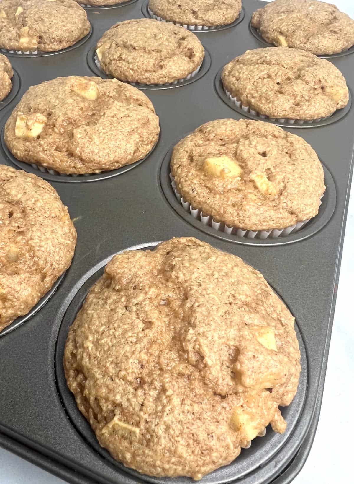 a dozen apple spice muffins in a muffin tin