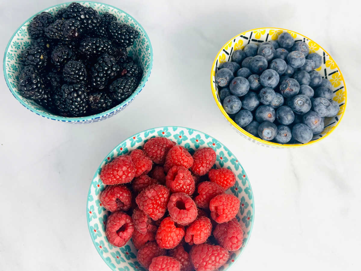 small bowls with raspberries, blueberries and blackberries