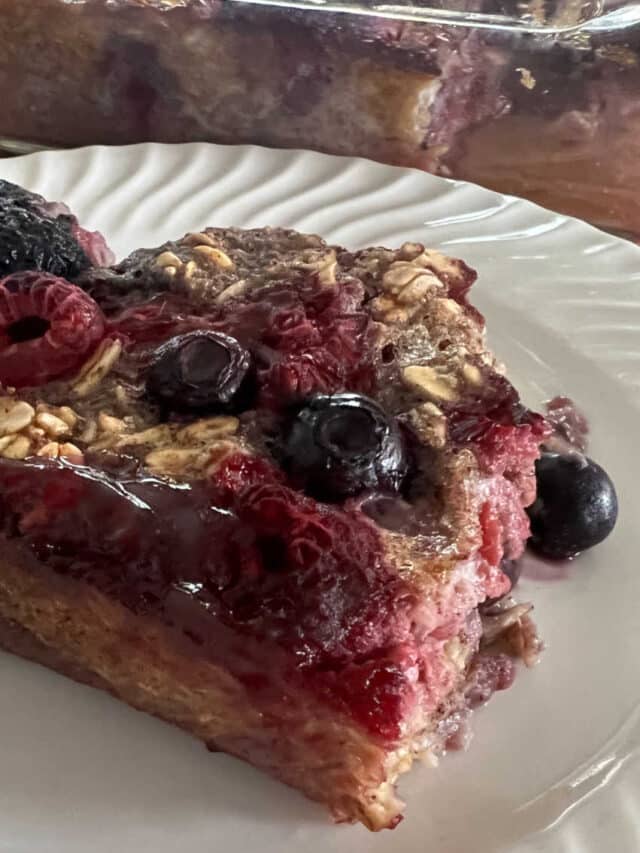 Berry oatmeal baked serving on a white plate. Lots of berries!