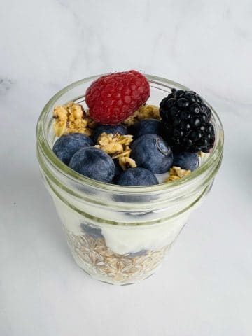 large yogurt and granola parfait in a mason jar with berries