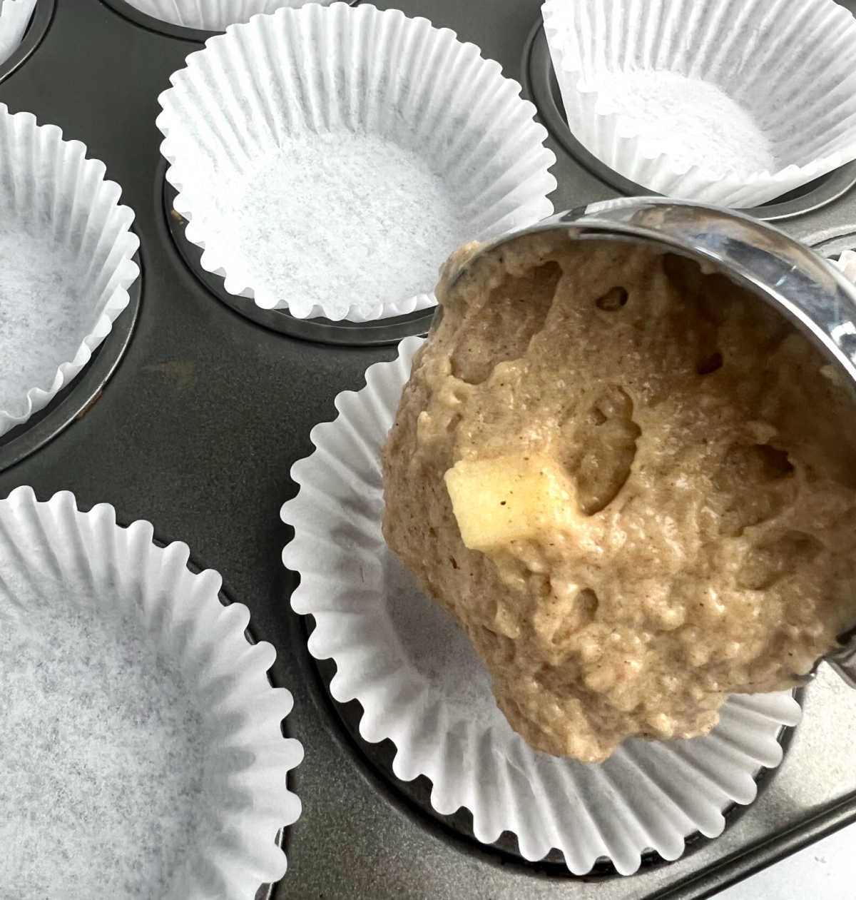 scooping batter into muffin tin