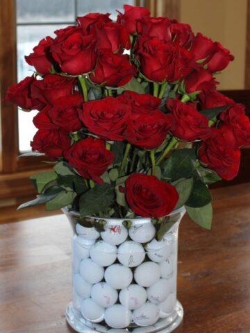 golf balls in vase with roses
