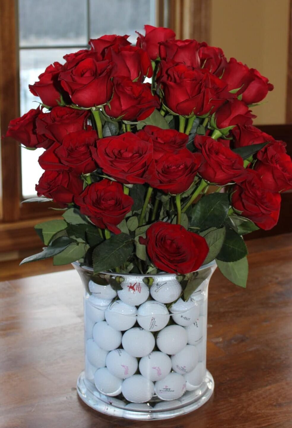 golf balls in vase with roses