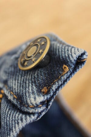 closeup of a new metal button on a jean