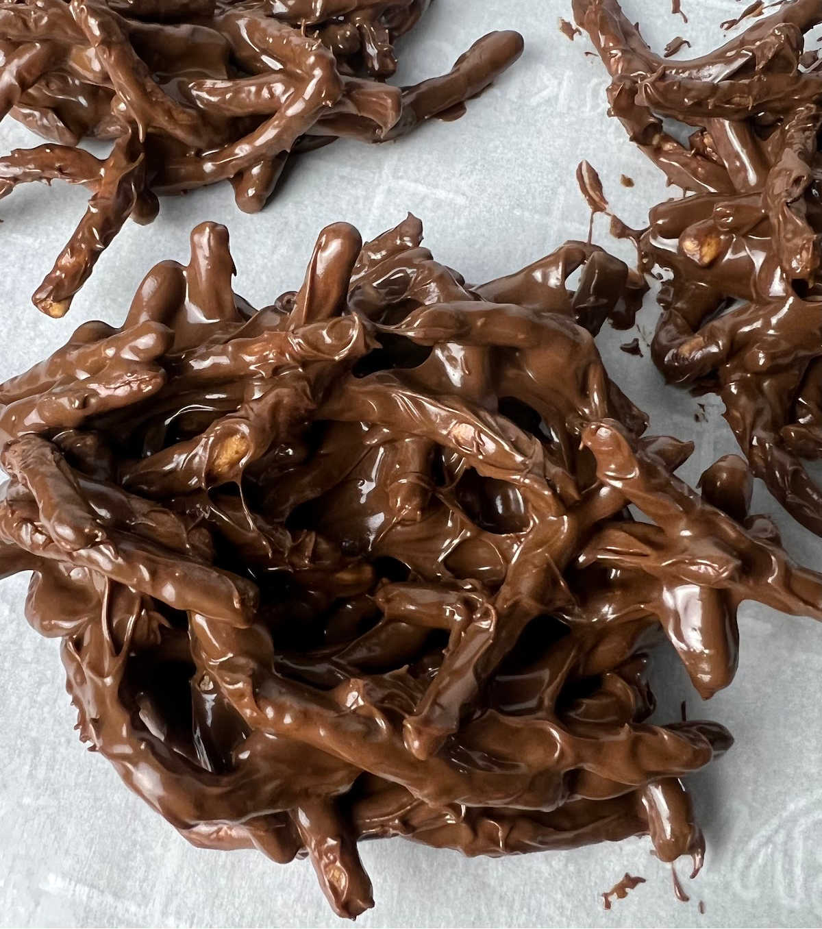 Chocolate covered chowmain noodles in piles on a baking sheet

