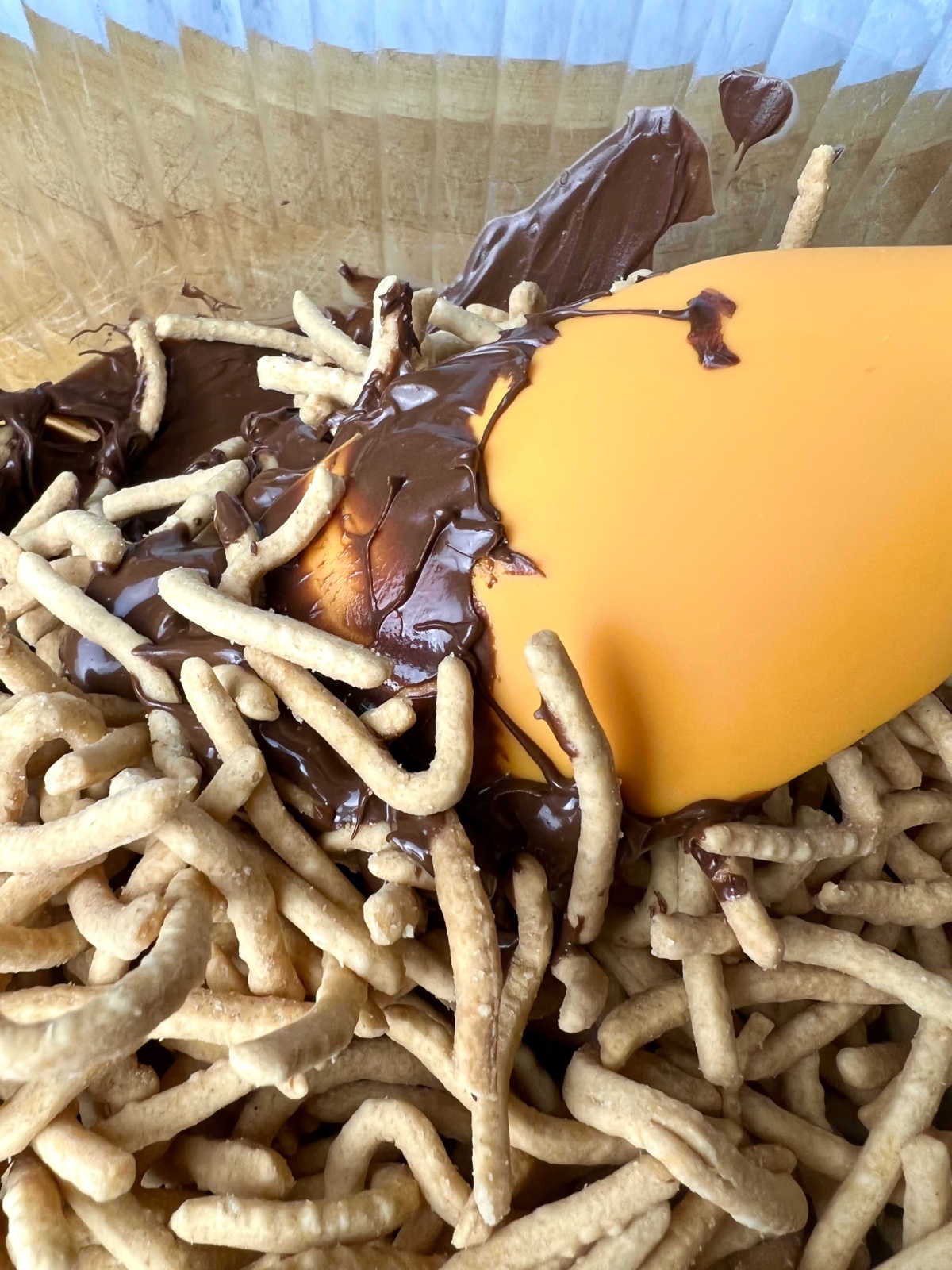 stirring chow mein into melted chocolate