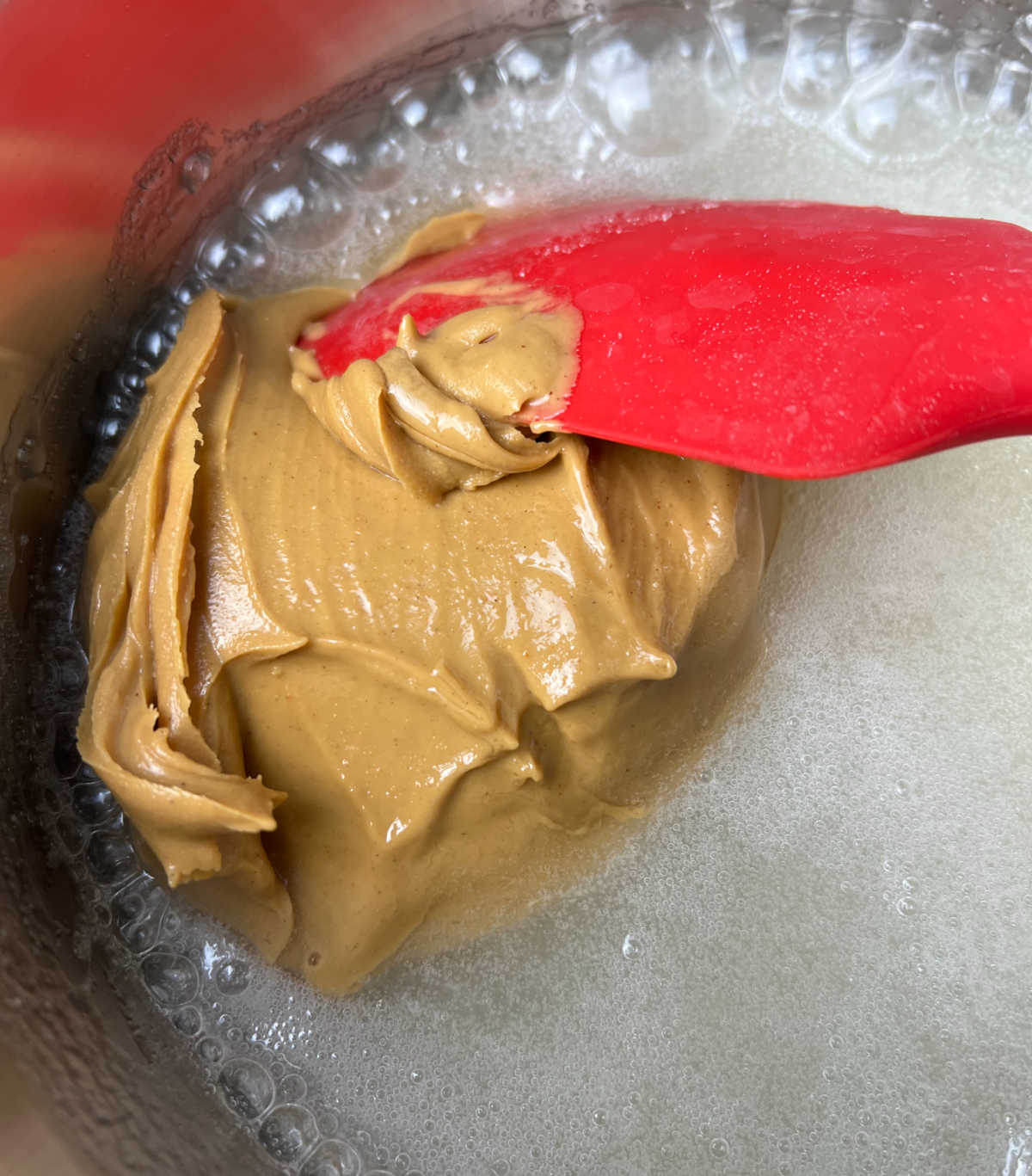 adding peanut butter to hot sugar mixture