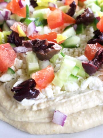 Mediterranian dip with hummus, chopped tomatos, cucumbers, feta and olives