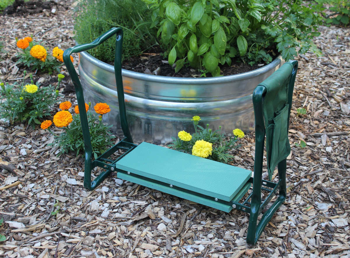 garden kneeler in front of raised herb garden.