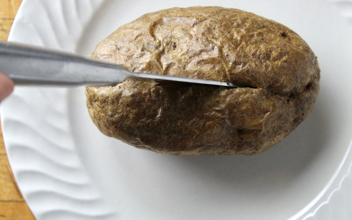 cutting into baked potato