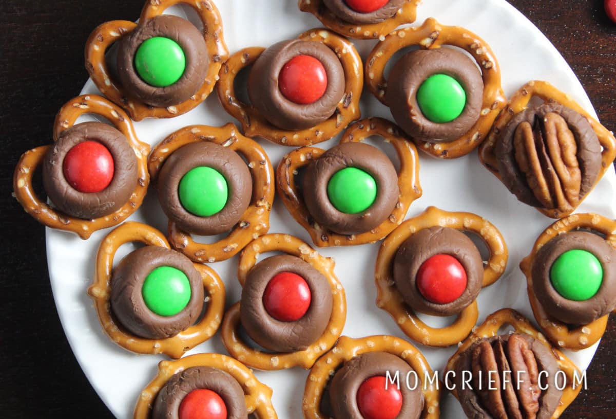red and green m&ms on hershey kiss chocolate on a mini pretzel