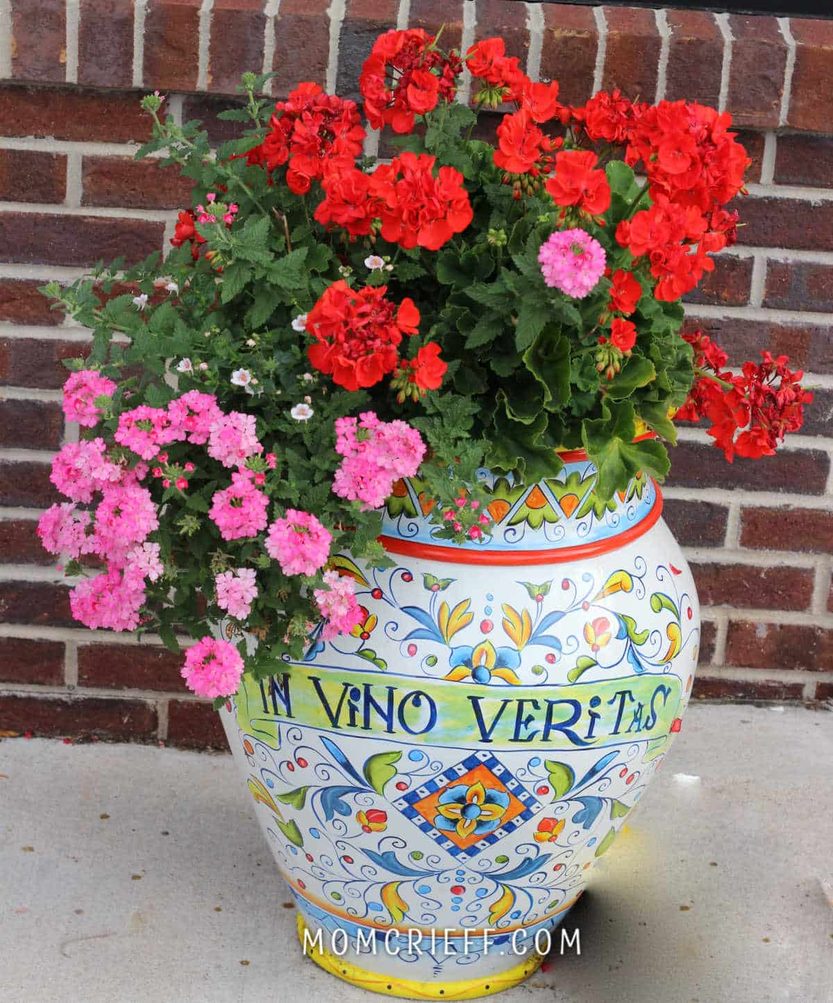 red geraniums and pink flowers in a Italian looking porcelain vessel as a planter