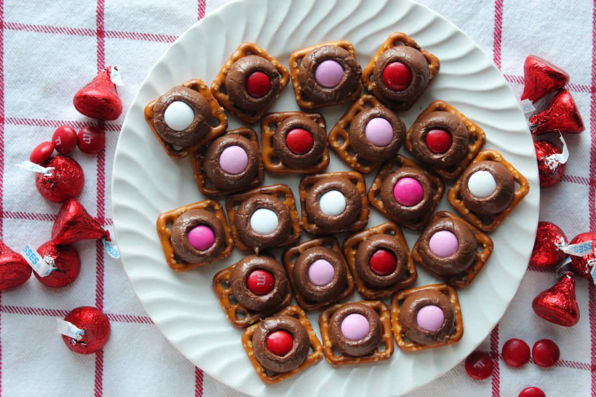 hershey kisses on pretzels with red, pink and white M & M's on top.