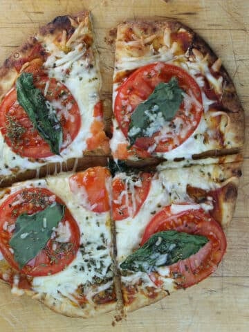naan bread pizza with tomatos, basil and cheese topping