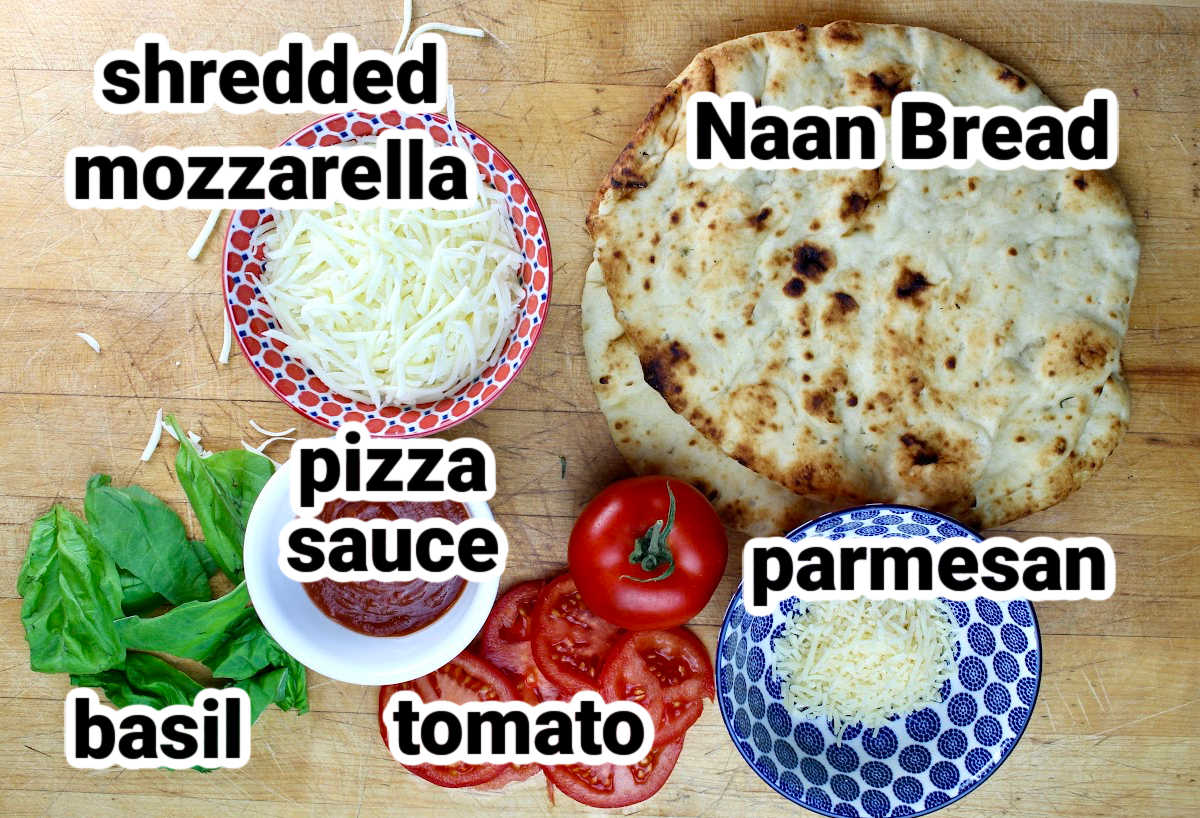 ingredients for naan pizza including naan bread, mozzarella, pizza sauce, parmesan, tomatos and basil
