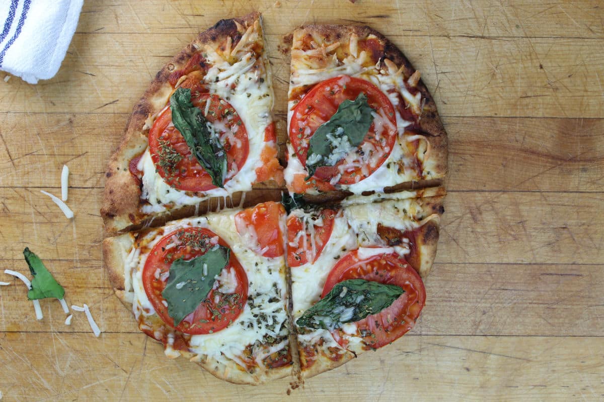 naan bread pizza with tomatos, basil and cheese topping