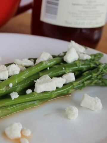 asparagus topped with balsamic vinegar and feta cheese.