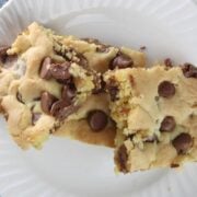 three chocolate chip cookie bars sitting on a white plate.