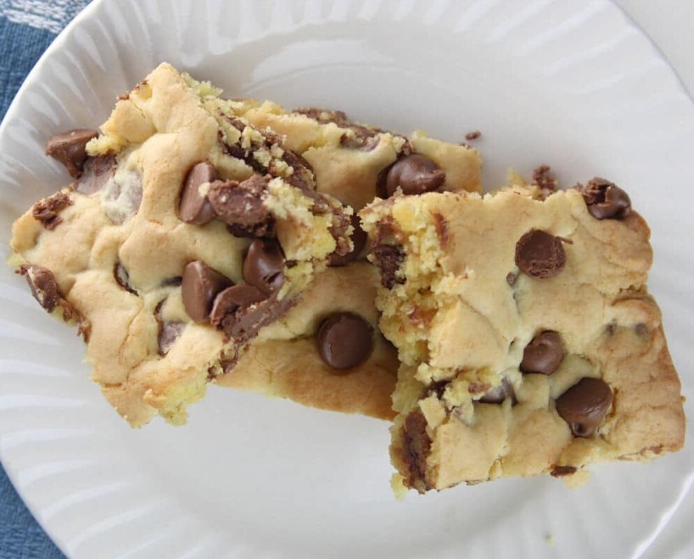 three chocolate chip cookie bars sitting on a white plate.