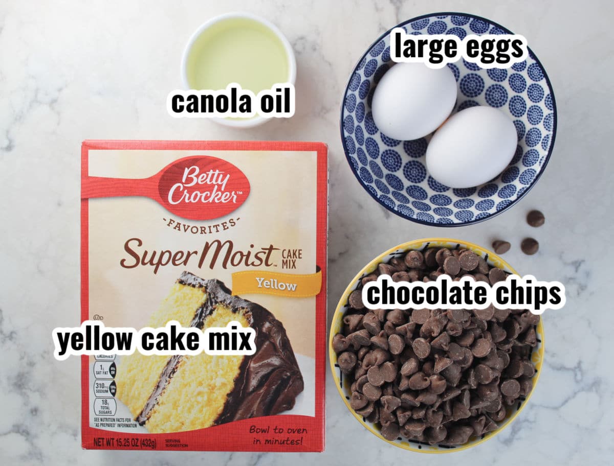 ingredients for cookie cake bars including canola oil, eggs, chocolate chips and yellow cake mix