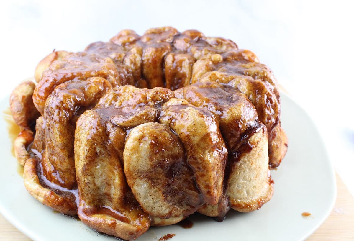 monkey bread with caramel sauce sitting on a white plate