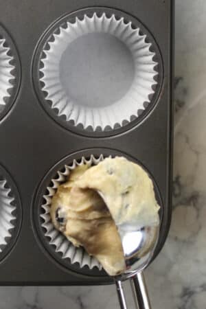 Using a scoop to portion muffin batter