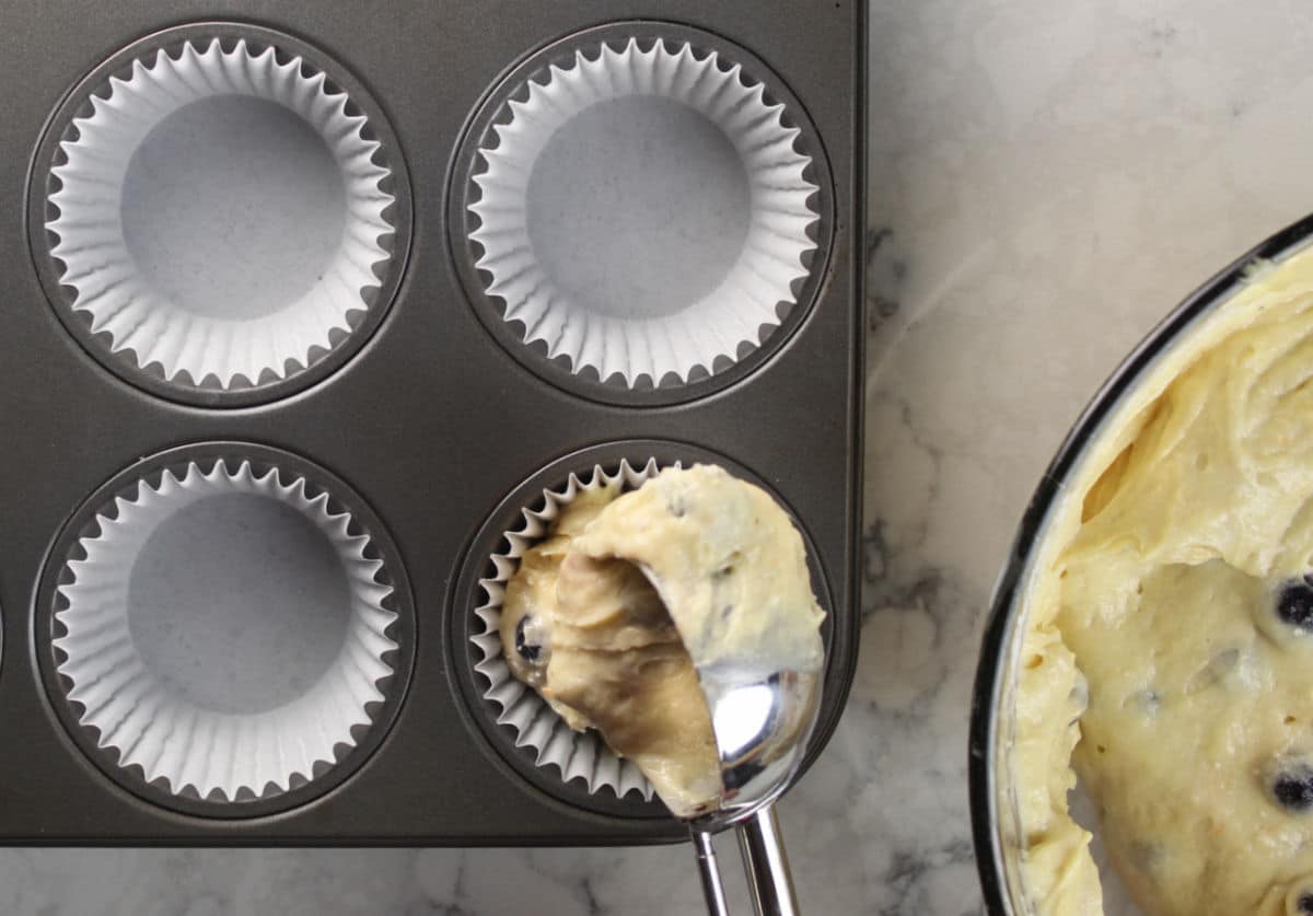 Using a scoop to portion muffin batter