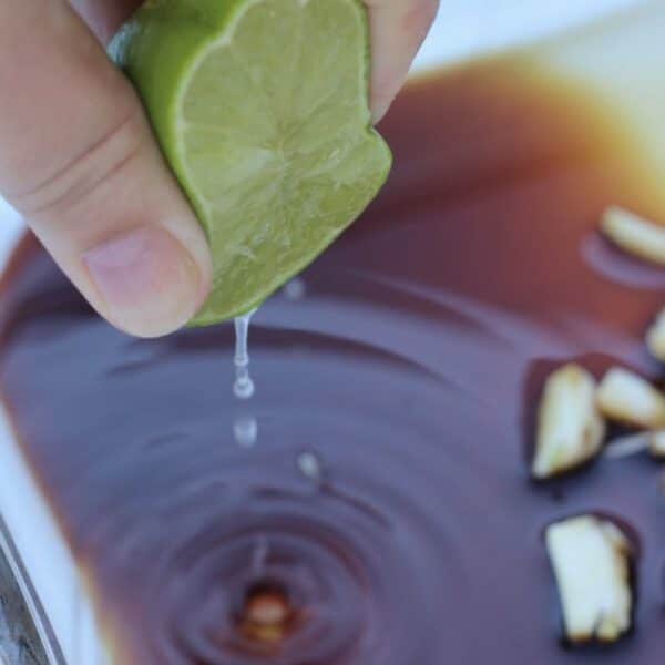 Squeezing fresh lime into pork chop marinade