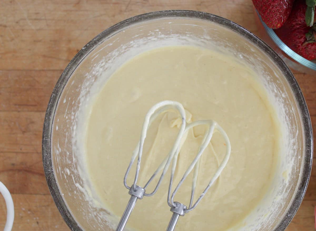 mixed batter in a bowl mix mixer beaters above batter.