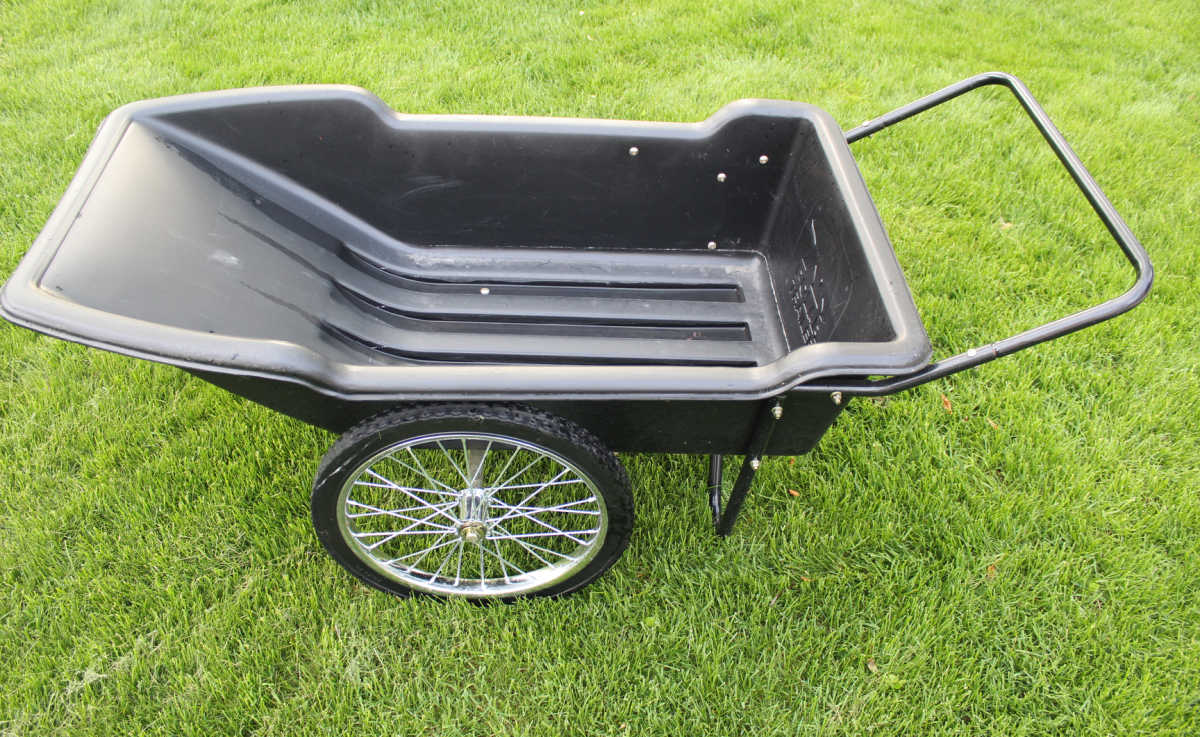 a yardcart with large wheels on the grass.