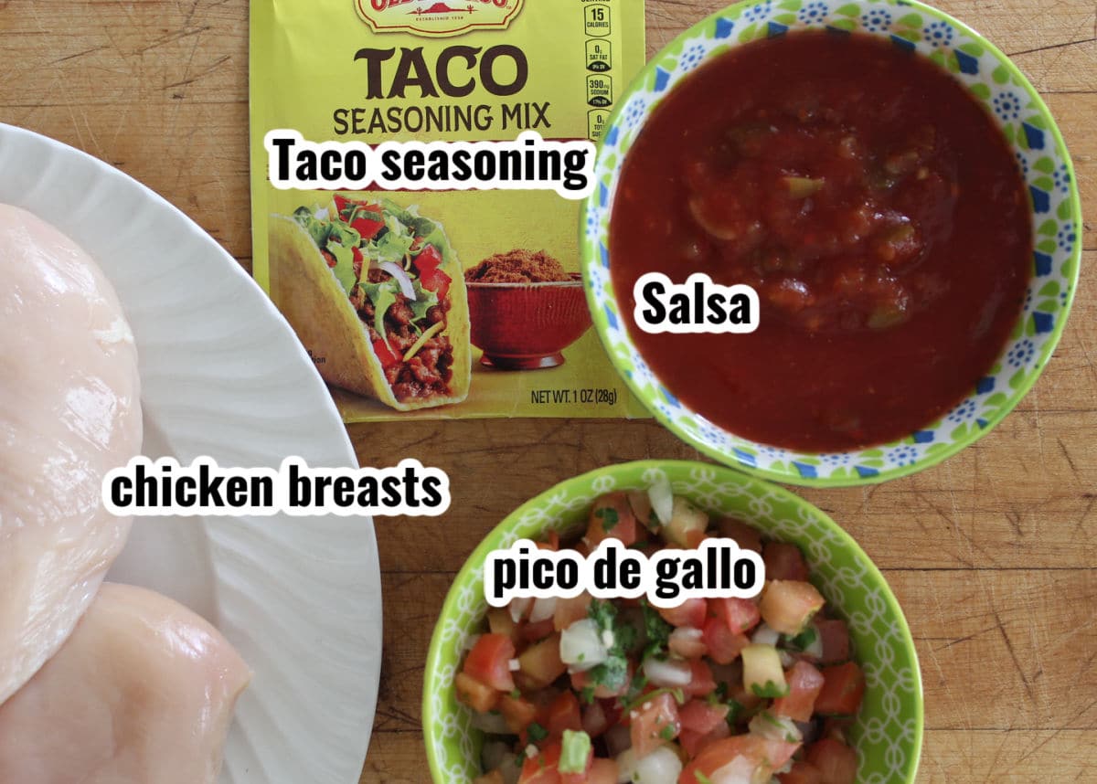 ingredients needed to make shredded chicken including taco seasoning, salsa, chicken breasts and pico de gallo.