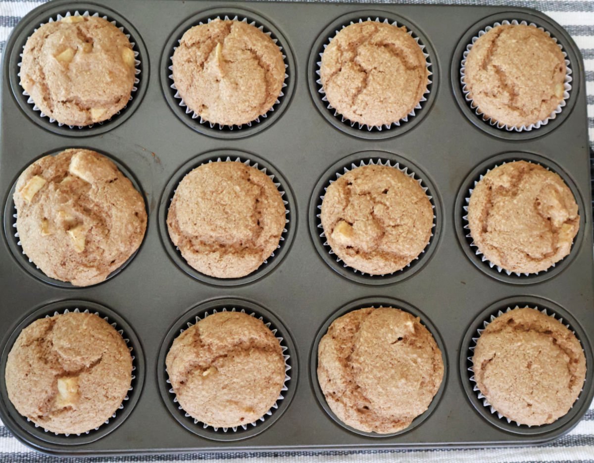 A dozen apple spice muffins in a muffin tin