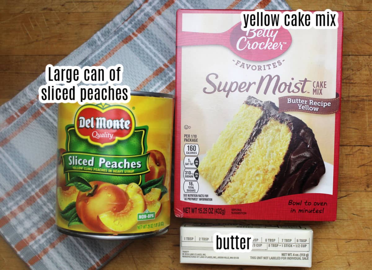peach dump cake ingredients which are a box of yellow cake mix, a large can of sliced peacches and a stick of butter.