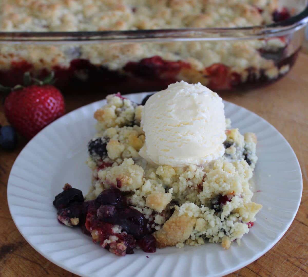 a serving of berry cobbler with a scoop of ice cream on top.