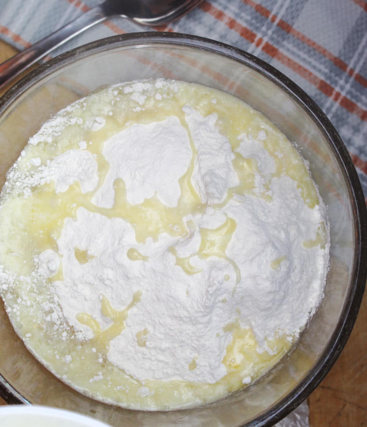 bowl containing ingredients from a can of sliced peaches, dry cake mix and melted butter.