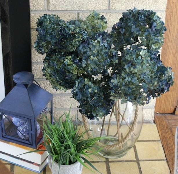 blue lantern with a large vase of blue hydrangeas