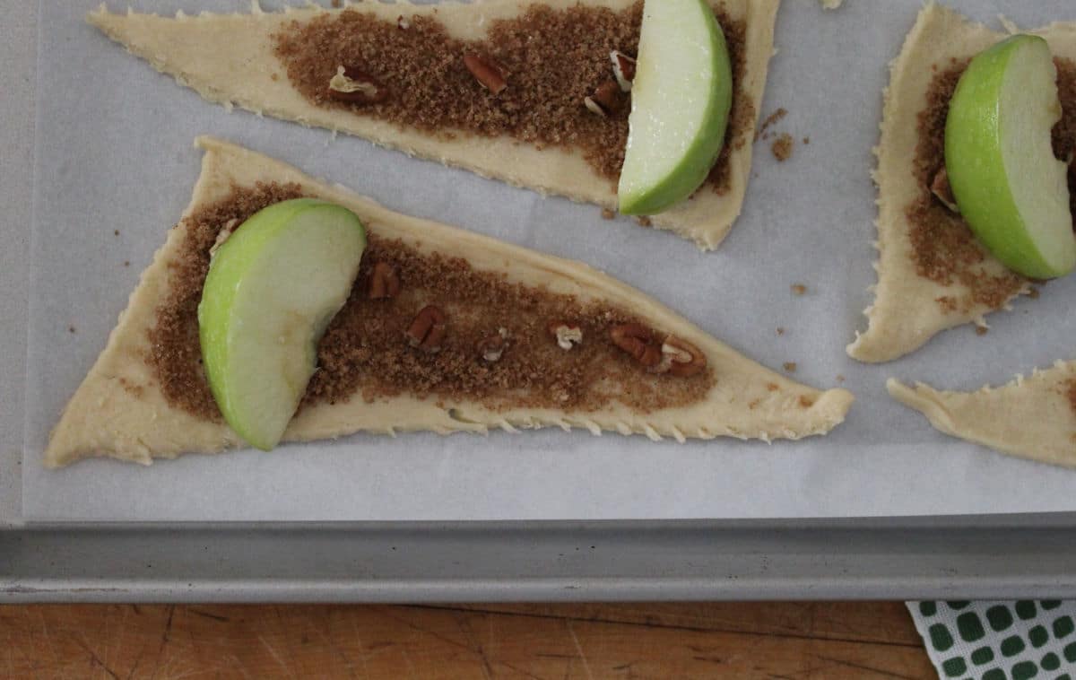 slice of apple on a crescent triangle covered in a brown sugar spice mixture.