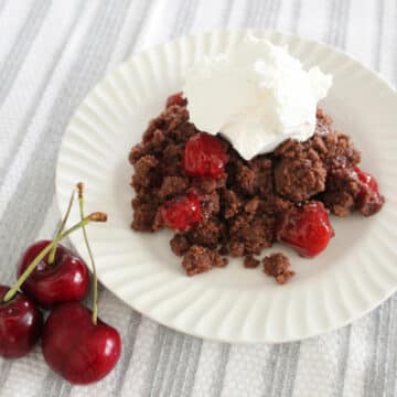 Chocolate cherry dump cake with a whipped topping on top.