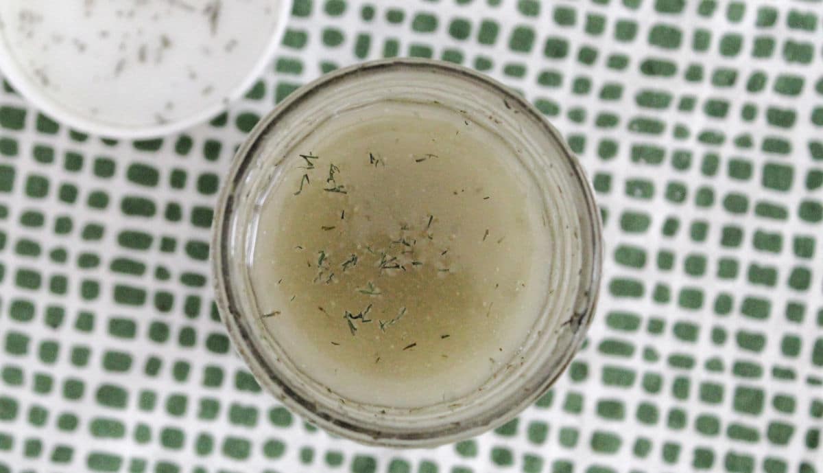 Close up of well mixed dill dressing in a jar.