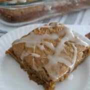 piece of pumpkin dump cake with icing drizzled on it.