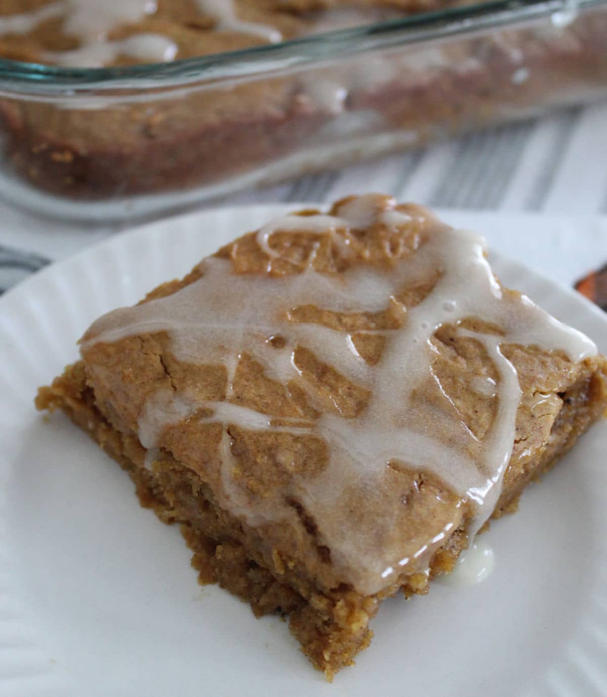 piece of pumpkin dump cake with icing drizzled on it.